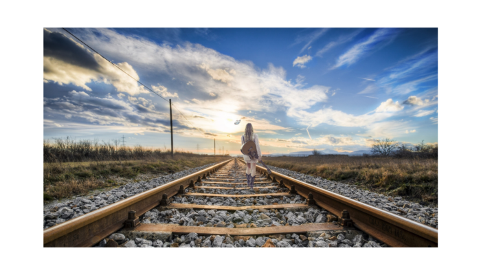 Frau auf Geleise wandernd