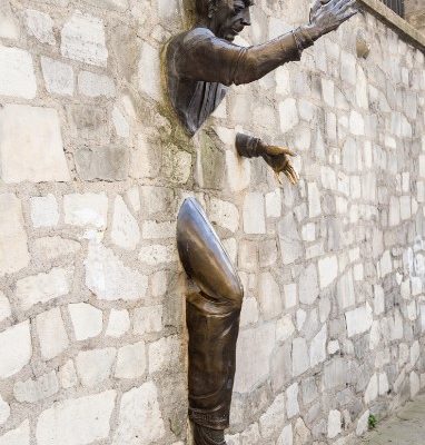 Männerskulptur durch Wand